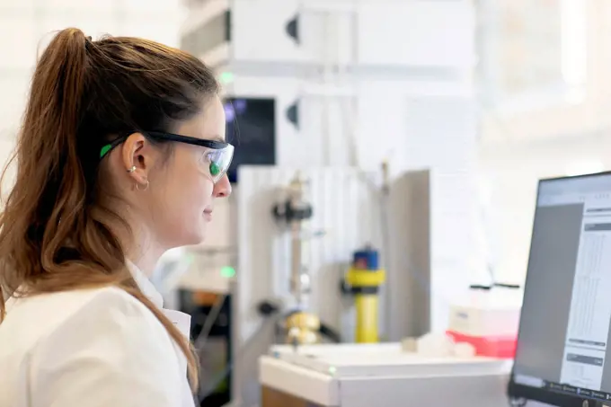 Scientist analyzing medical test results on computer in laboratory