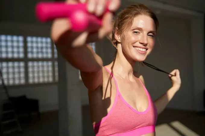 Smiling woman holding skipping rope