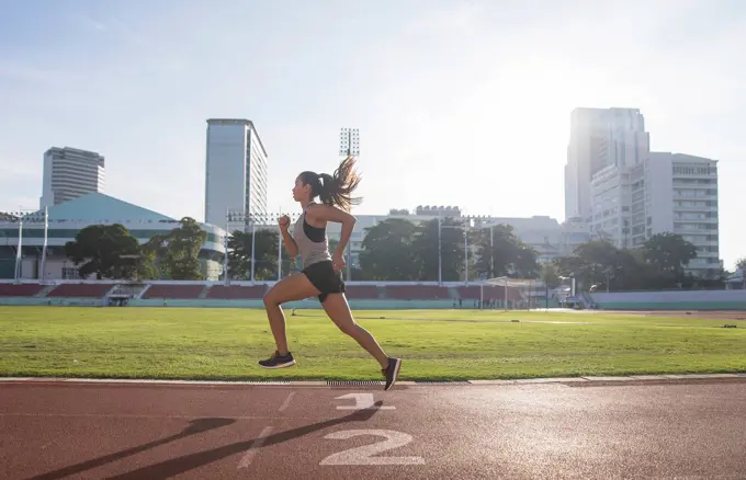 Young woman running in sports field