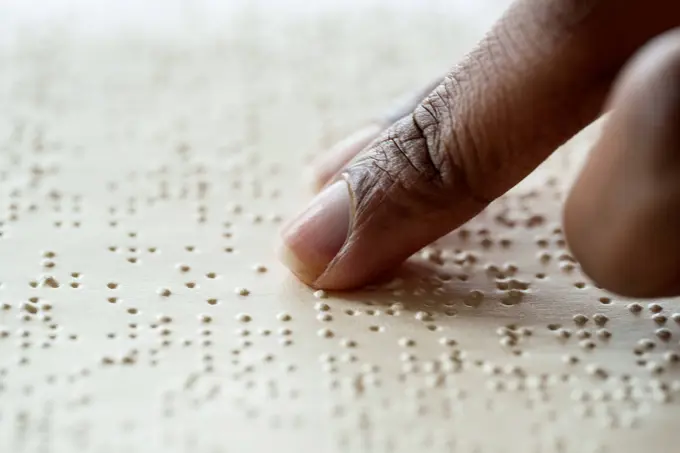 Woman reading braille text from book