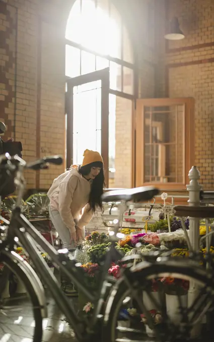 Woman choosing flowers to buy at shop