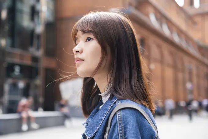 Young woman in front of building at street