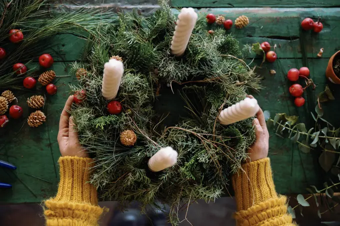 Florist making wreath on table in store