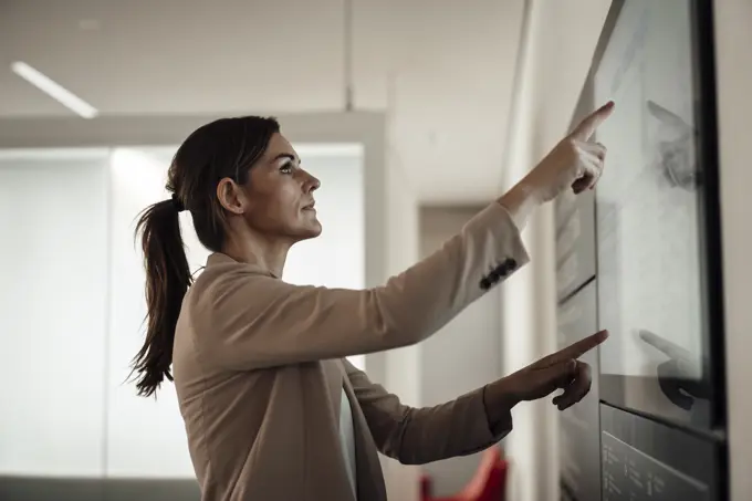 Businesswoman using digital screen and working at office