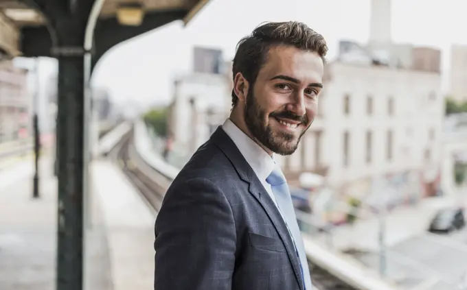 Smiling young businessman waiting at subway station