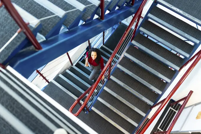 Businesswoman moving down from stairs at office