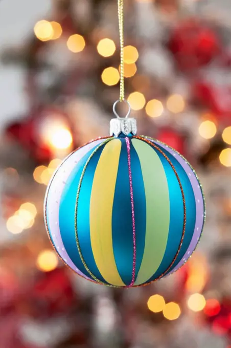 Christmas bauble hanging in front of blurred flares