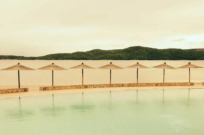 Croatia, Sibenik, Sunshades, Swimming pool of a hotel facility, Evening mood