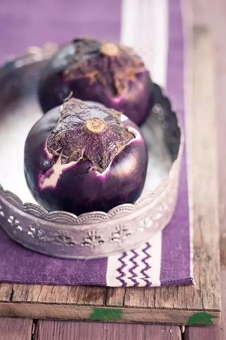 Two eggplants, Solanum melongena, on a tray