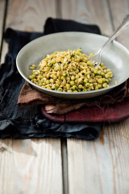 Bowl of kamut and peas on cloth and wood