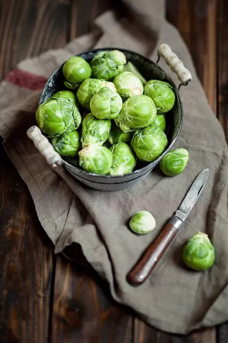 Peeled brussel sprouts in tin bucket, knife, studio