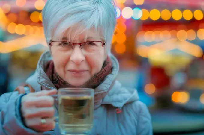 Senior woman holding glass of mulled wine