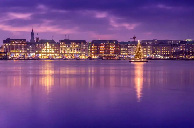 Germany, Hamburg, Downtown skyline with illuminated Christmas tree on Alster river