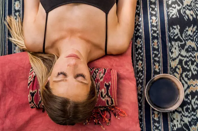 Woman lying on blanket meditating