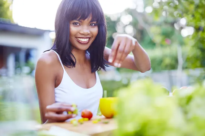 Young woman preparing healthy meal in garden