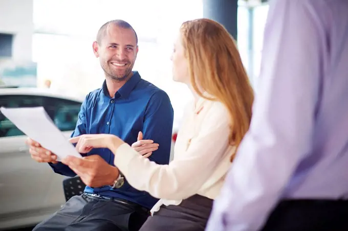 Couple at car dealer buying new car