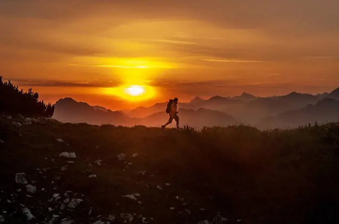 Austria, Salzburg Country, Man hiking through Niedere Tauern mountains at sunrise