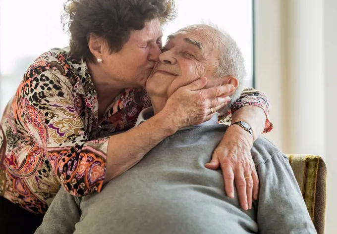 Senior woman hugging and kissing his husband