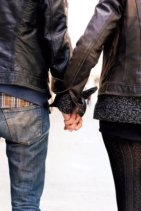 Man and woman holding hands on the street