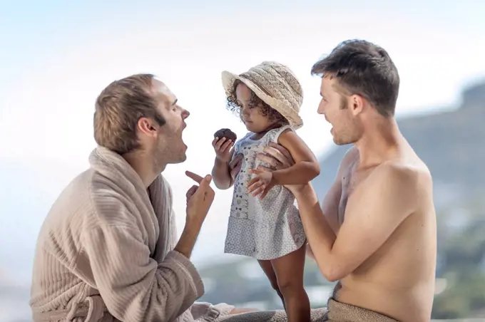 Gay couple with daughter outdoors