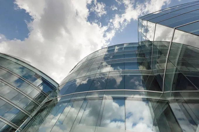 Switzerland, Geneva, glass facade of modern office building with reflections of clouds