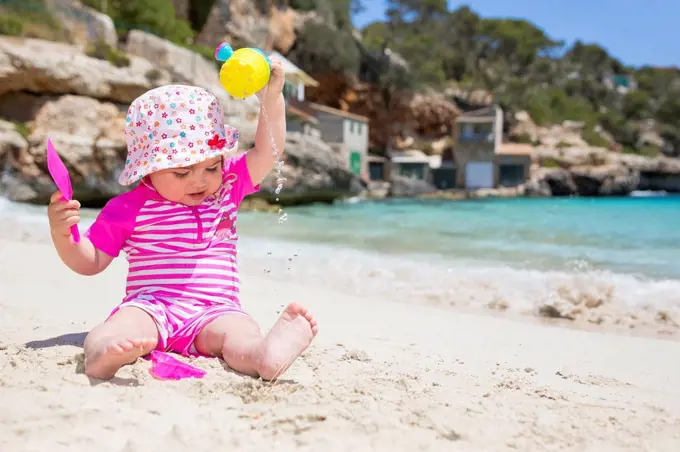 Spain, Baleares, Mallorca, baby girl playing on sandy beach