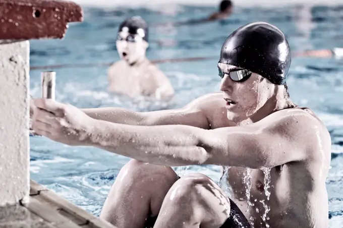 Backstroke swimmer in indoor pool in starting position