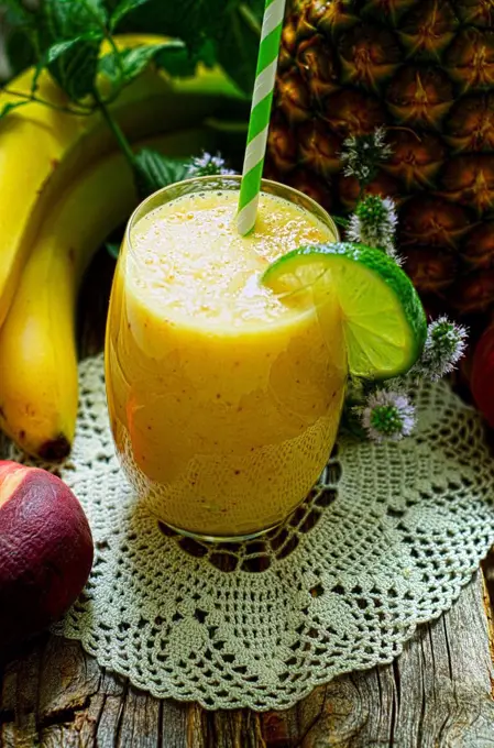 Smoothie of bananas, pineapple and mint on a wooden table