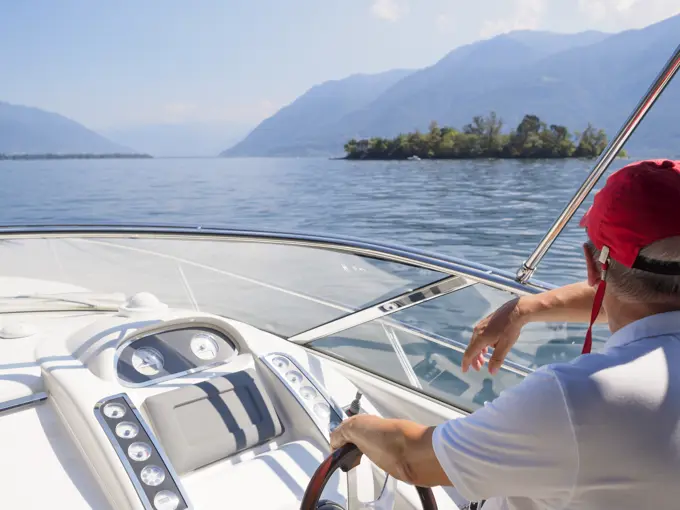 Switzerland, Ticino, Lago Maggiore, senior man on boat