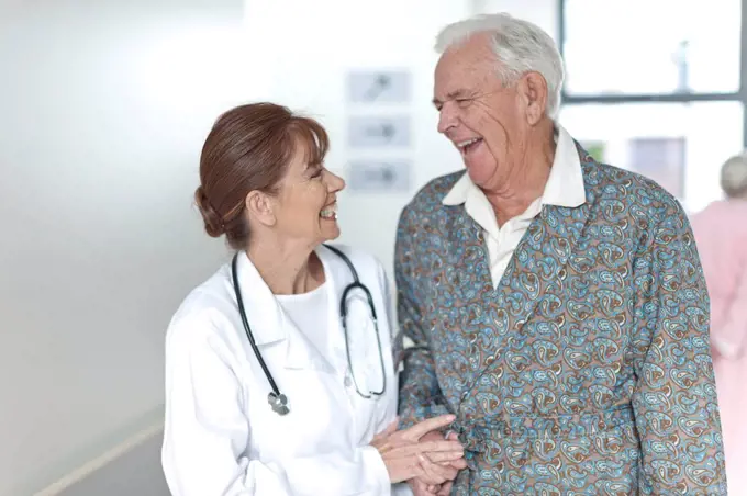 Doctor with happy elderly patient on hospital floor