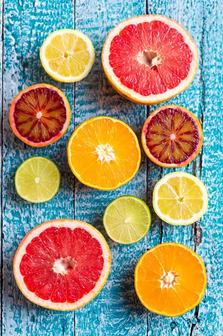 Sliced citrus fruits on light blue wood