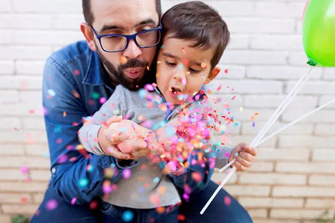 Father and his little son blowing confetti