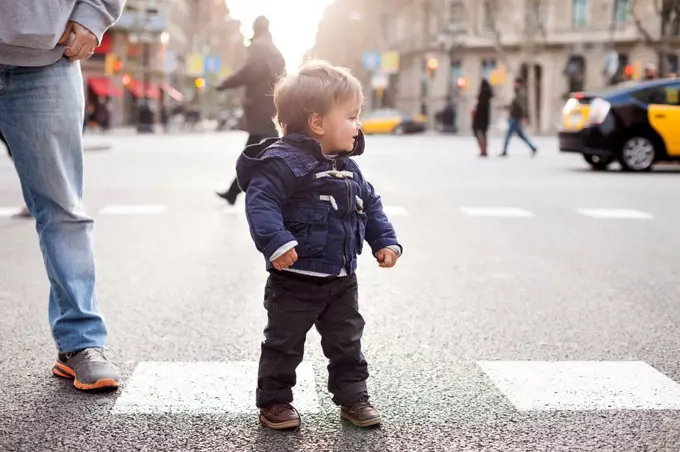 Spain, Barcelona, little boy standing on a road