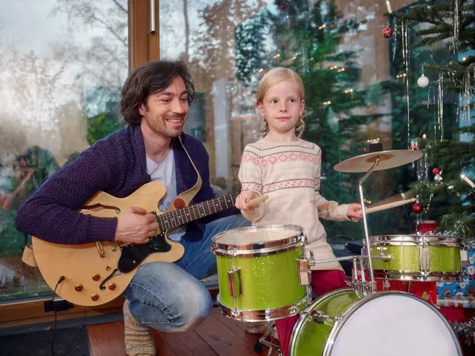 Father and daughter playing music on Christmas Eve