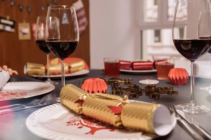 Set Christmas dinner table with Christmas crackers