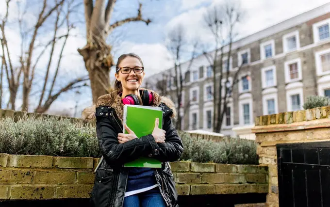 London, student girl with headphone and writing pad, language holiday