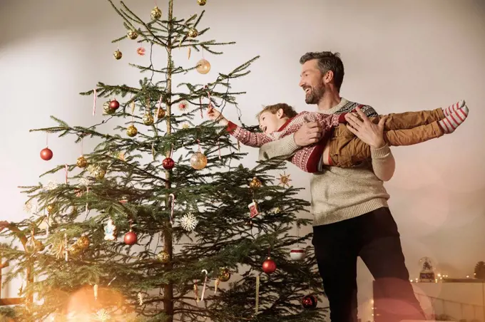 Father and son decorating Christmas tree