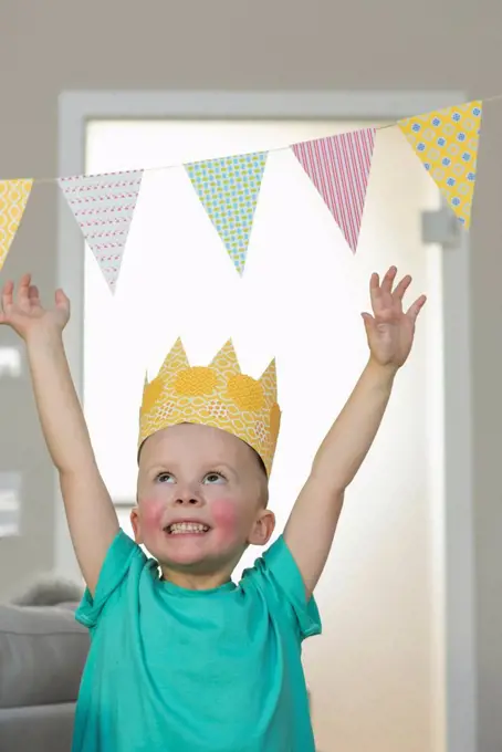 Happy boy wearing paper crown