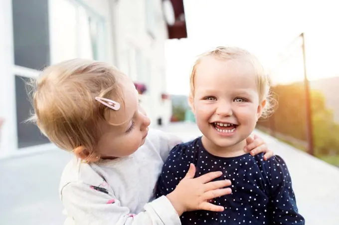 Little girl watching her laughing sister