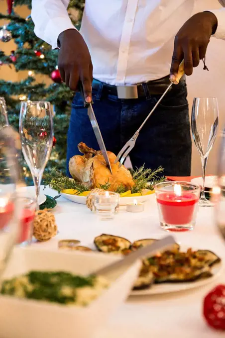 Man carving a roast chicken for Christmas dinner