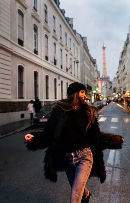 France, Paris, young woman on the street with the Eiffel Tower in the background