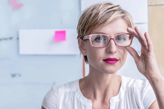 Portrait of businesswoman in front of whiteboard in modern office