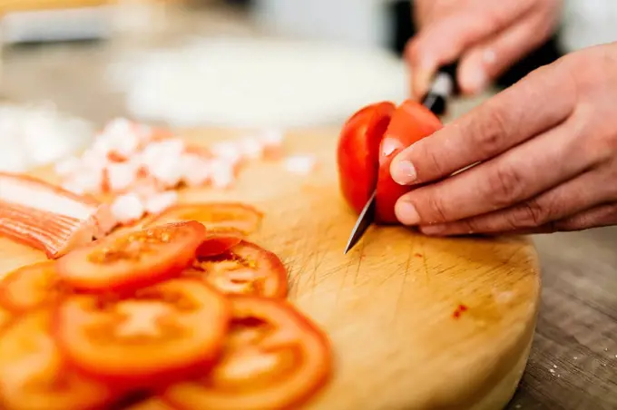 Slicing tomatoes in kitchen