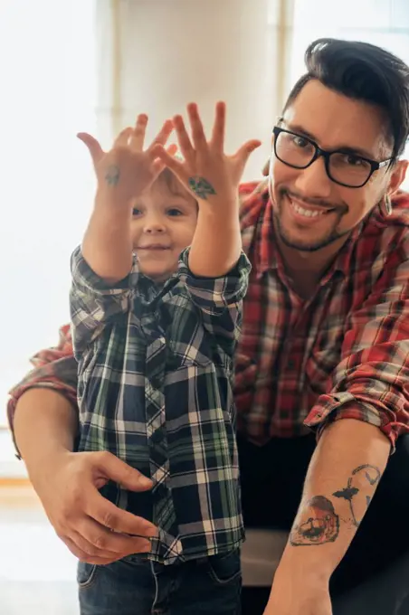 Proud son showing painted tattoos on his hands