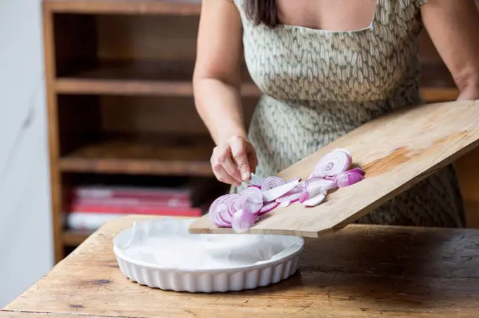 Woman preparing red onions for onion pesto