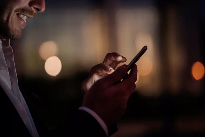 Close-up of businessman text messaging