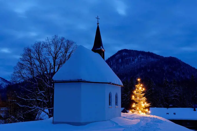 Germany, Lenggries, chapel and lighted christmas tree