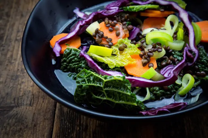 Bowl of vegan cabbage stew with lentils, partial view