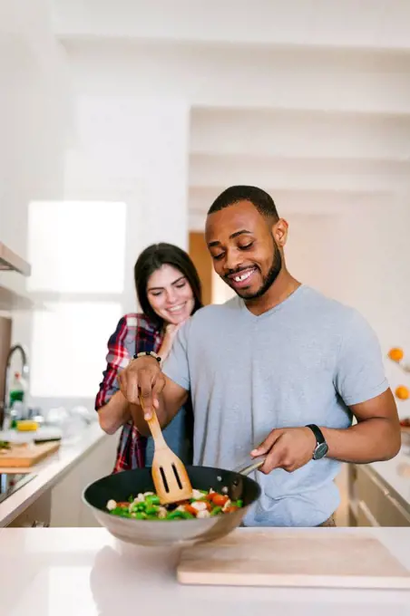 Young couple cooking together at home