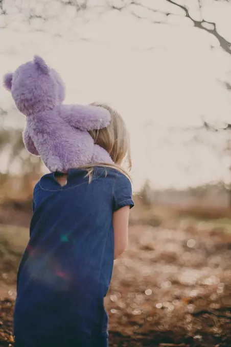 Girl carrying a teddy on her shoulders